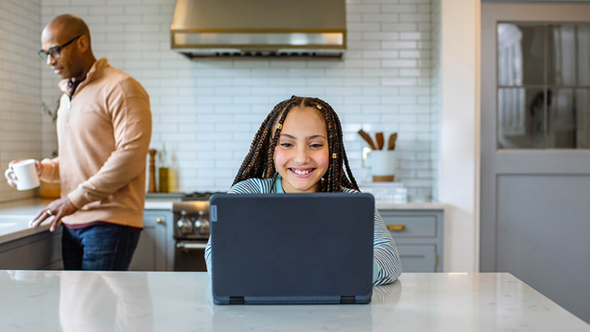 Young girl using a laptop in the kitchen