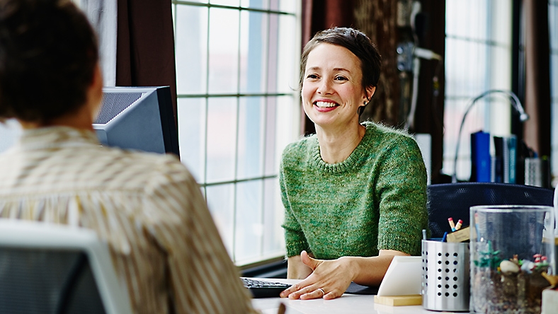 Two people having a conversation over a desk