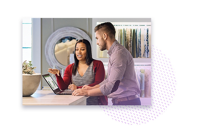 Two people having a conversation and viewing data on a laptop