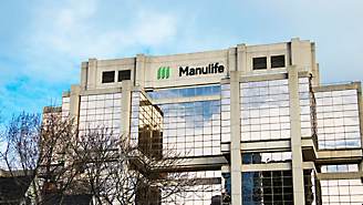 Moderne kontorbygning med manulife-logo på facaden mod en overskyet himmel.