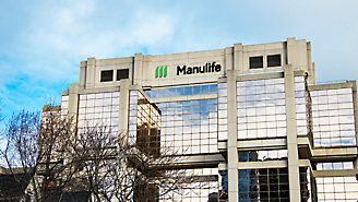 Modern kantoorgebouw met het manulife-logo op de façade en een bewolkte hemel.