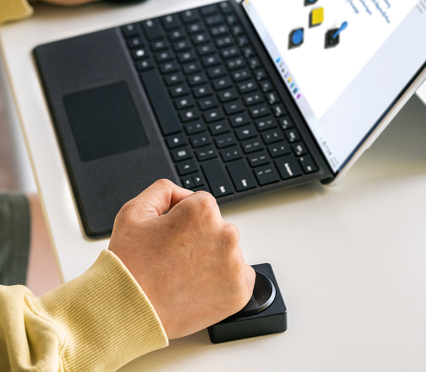 A person uses Microsoft Adaptive D-pad Button with their Surface device.