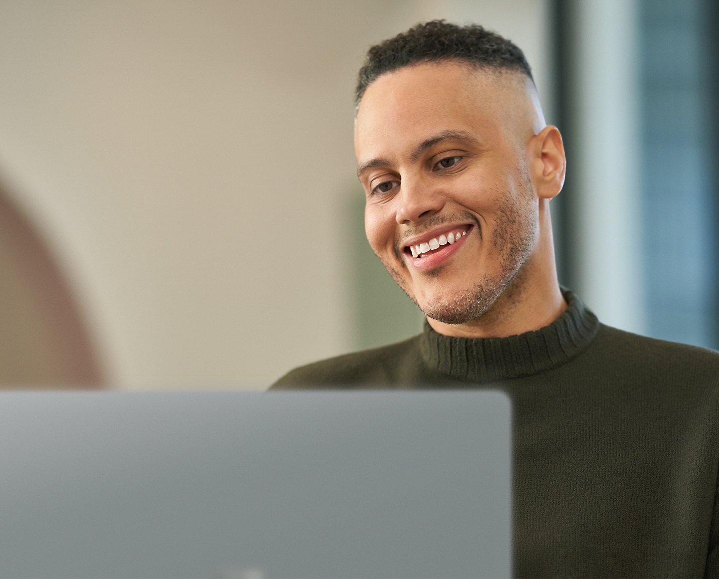 A person working on his laptop and smiling