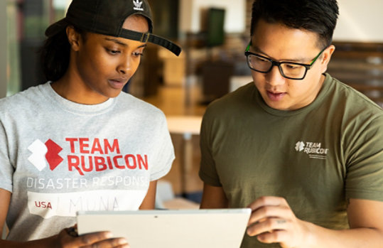 一緒にタブレットを見ている Team Rubicon のメンバー。