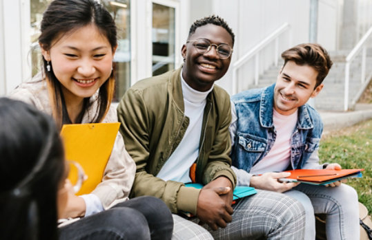 A group of young students sitting in an urban green space.