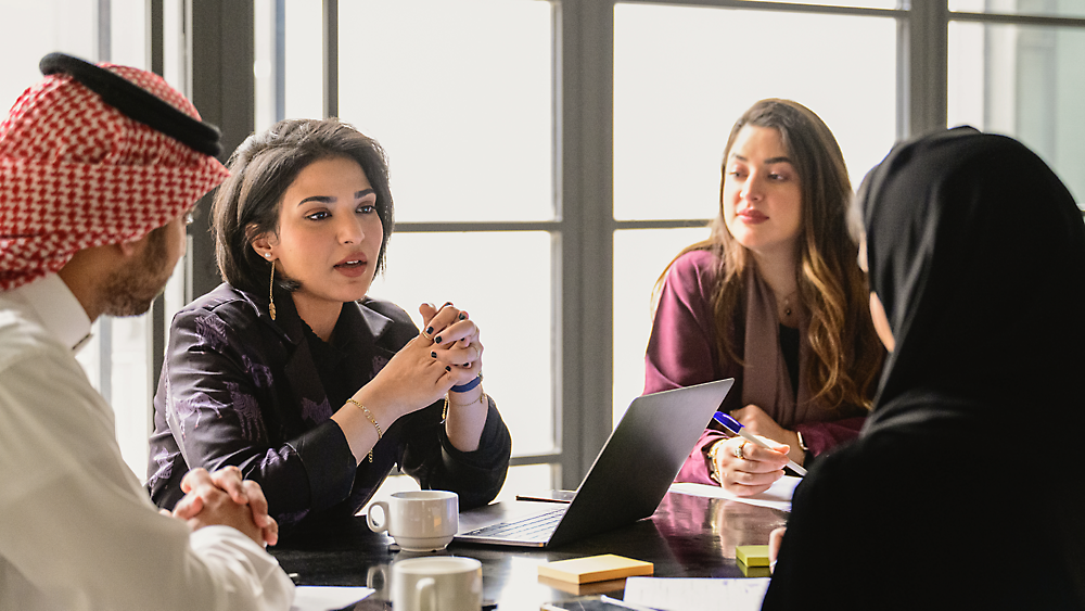 A diverse group of professionals, including men and women wearing traditional and western business attire