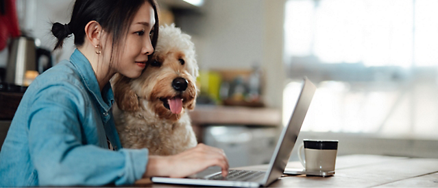 Человек с собакой использует компьютер