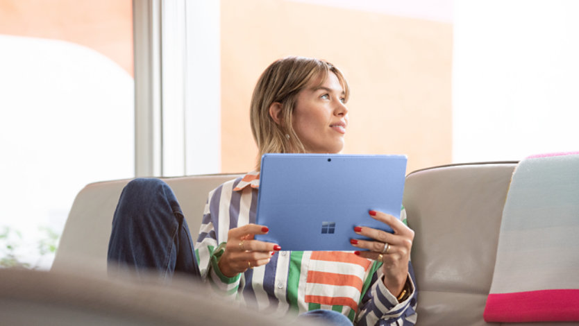 Eine junge Frau mit einem Surface Pro 9. 