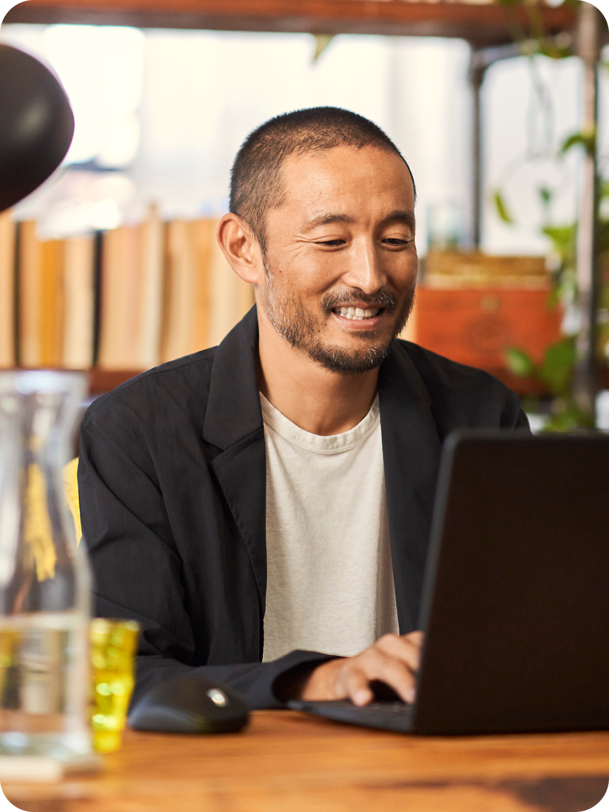 A man smilling while using laptop.