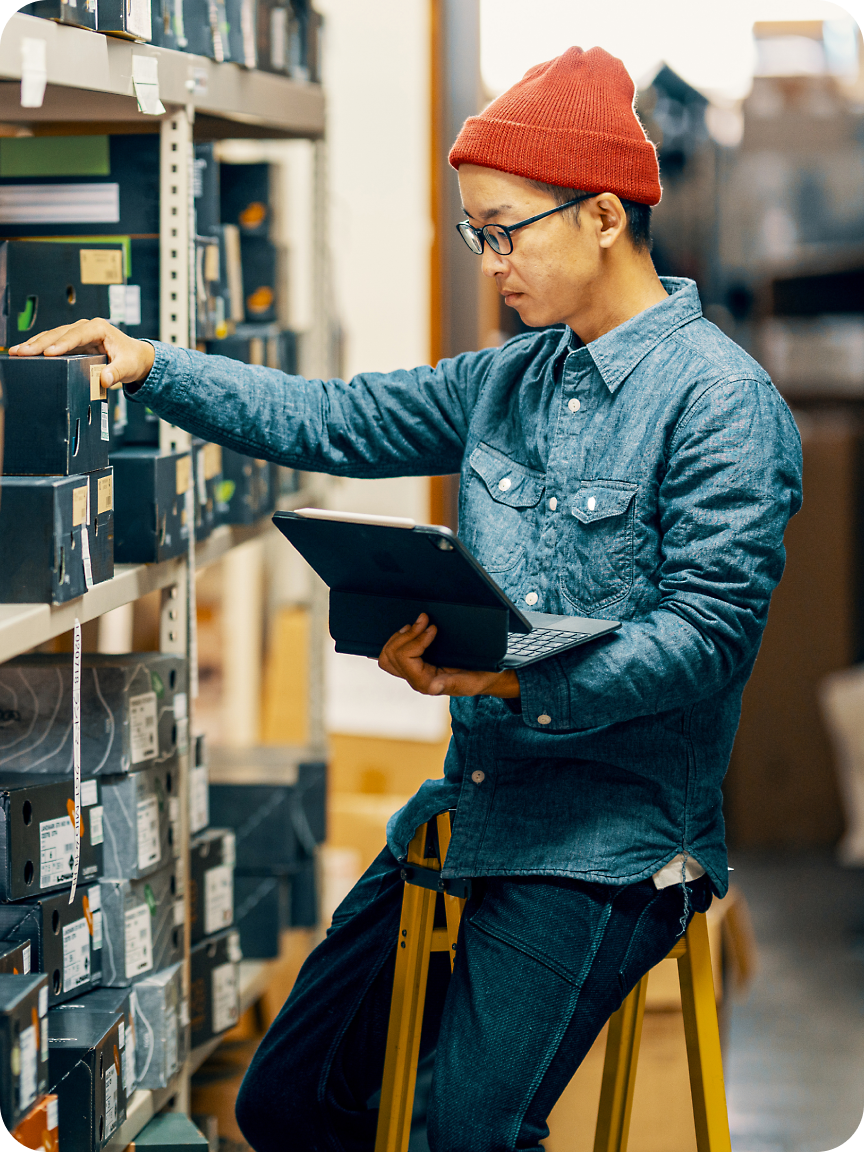 A man using a laptop near the shelf