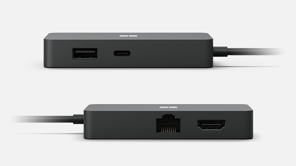 Obie strony koncentratora Travel Hub z widocznymi portami USB, Ethernet i HDMI.