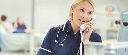 En sykepleier som snakker på telefonen på et sykehus.