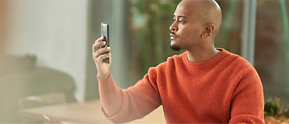 En mann tar et bilde på mobiltelefonen sin.
