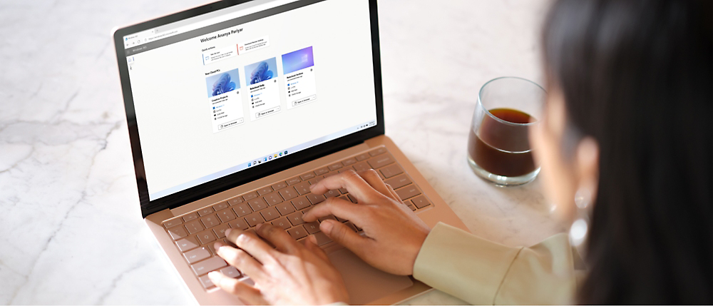 Ragazza che scrive a computer mentre beve una tazza di caffè.