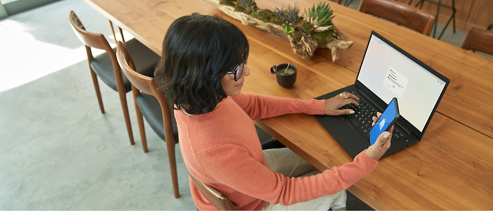 Egy asztalnál ülő, számítógépet használó személy