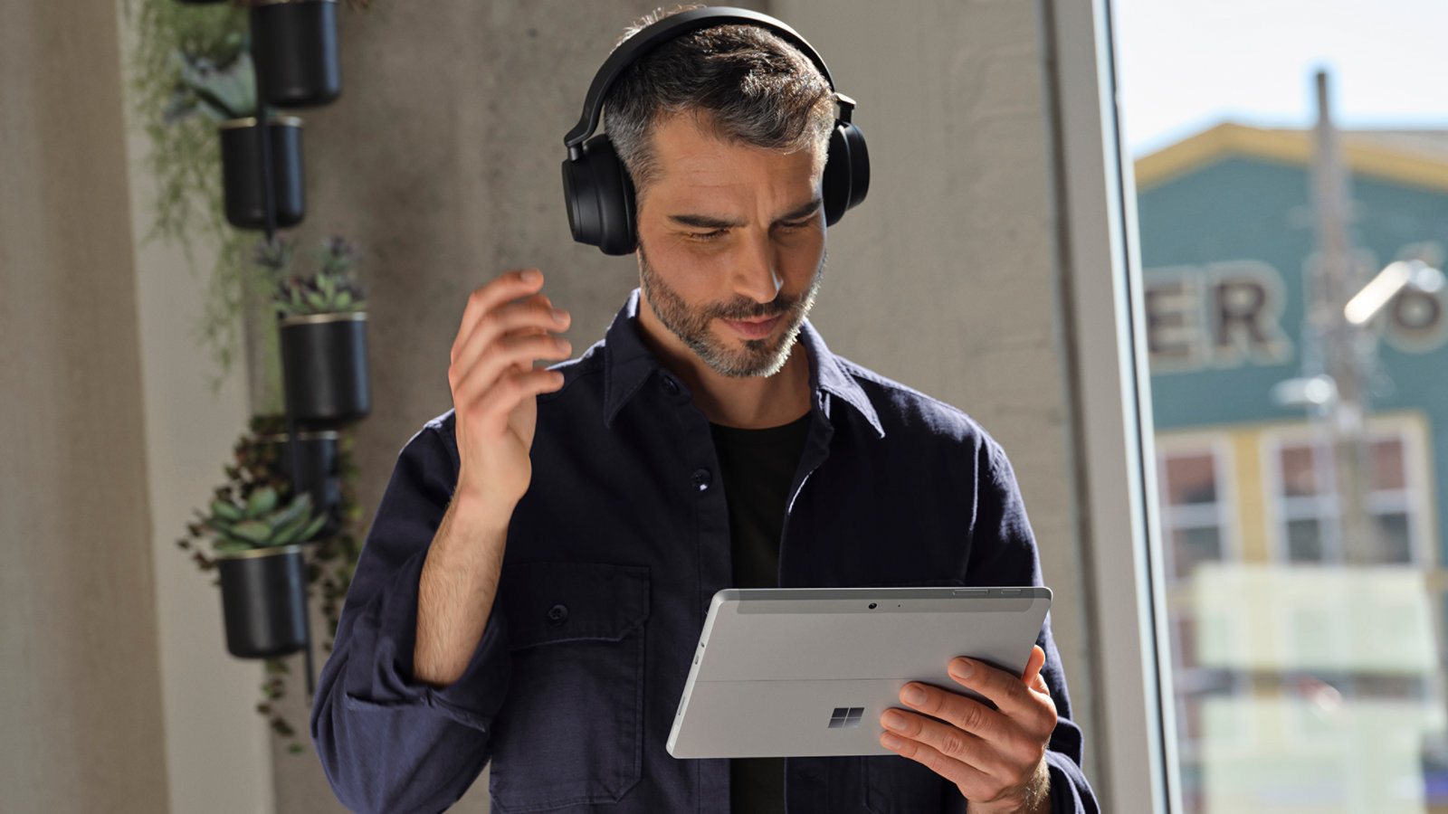 Una persona con cascos usa un dispositivo Surface Go 4 para empresas para hacer una videollamada.