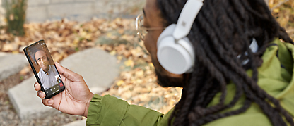 En person med hovedtelefoner, der ser noget på en mobil