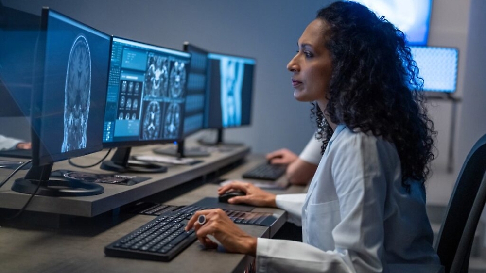 A person in a lab coat working on a computer