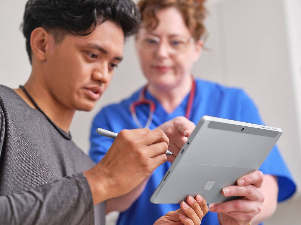 Zwei Personen, die auf ein Tablet schauen