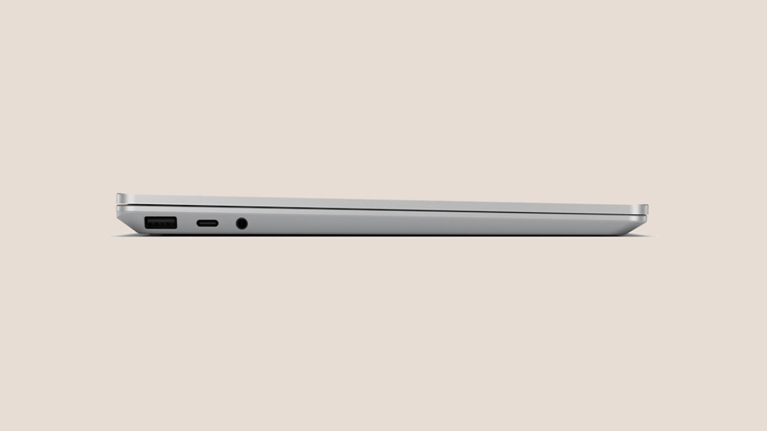 持ち運びやすさを示す、閉じたプラチナの Surface Laptop Go 3 を側面から見た画像。