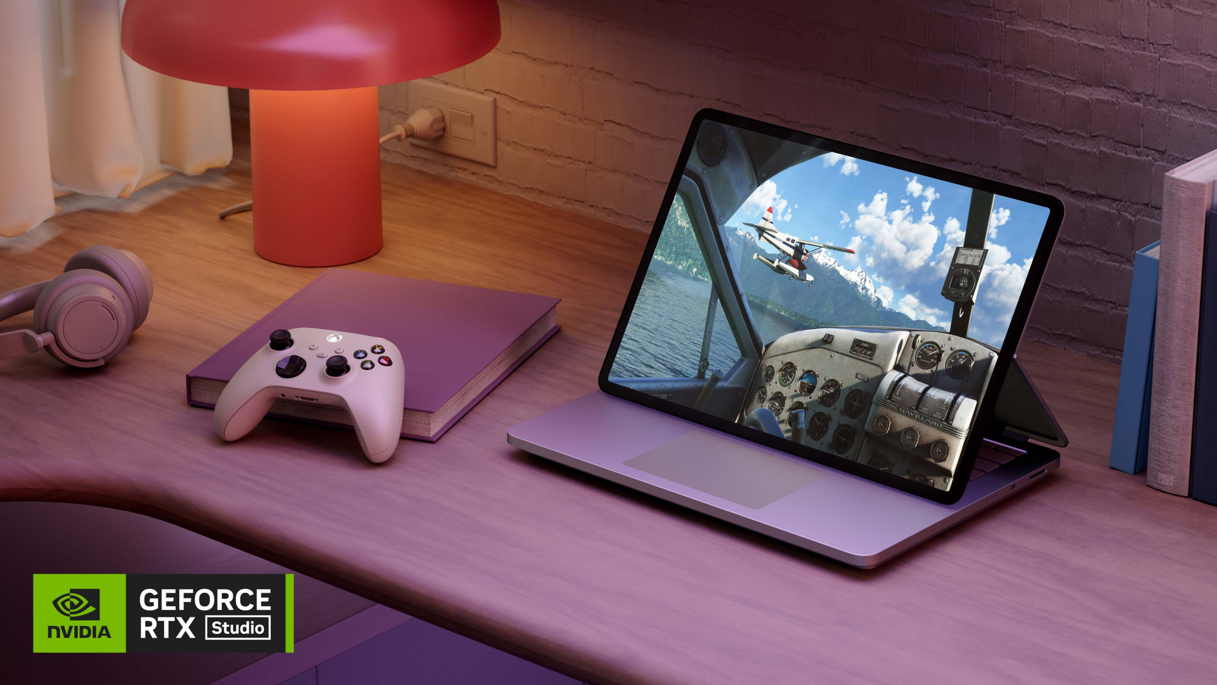 Surface Laptop Studio 2 in podiummodus naast een koptelefoon, een gamecontroller en een boek op een houten bureau.