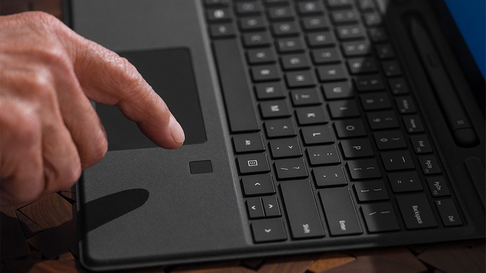 Et nærbillede af en person, der logger ind med sit fingeraftryk på et Surface Pro Signature Keyboard med fingeraftrykslæser.