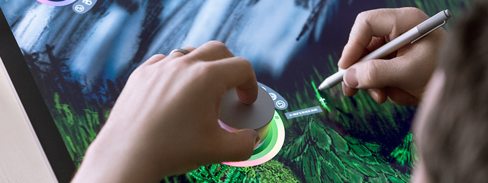 A person uses Surface Dial on the screen of Surface Studio 2.