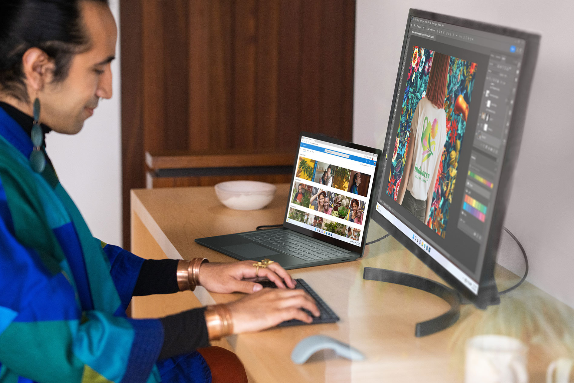 En person sitter ved et skrivebord og skriver på et eksternt tastatur med både Surface Laptop 5 og en ekstern skjerm som viser bilder på skjermen.