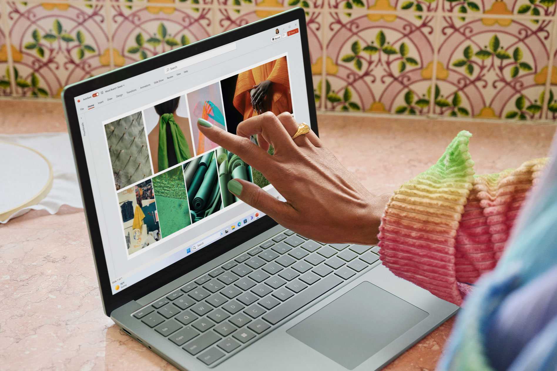 A close-up view of a person interacting with the touchscreen on their Surface Laptop 5.