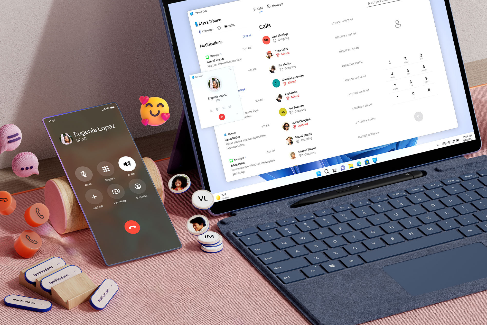 Surface Pro 9 na biurku z powiadomieniami o rozmowach telefonicznych wyświetlonymi na ekranie i telefon komórkowy leżący obok z ikonami czatu i emotikonami unoszącymi się wokół niego