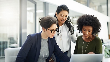 Three people working together at a desk