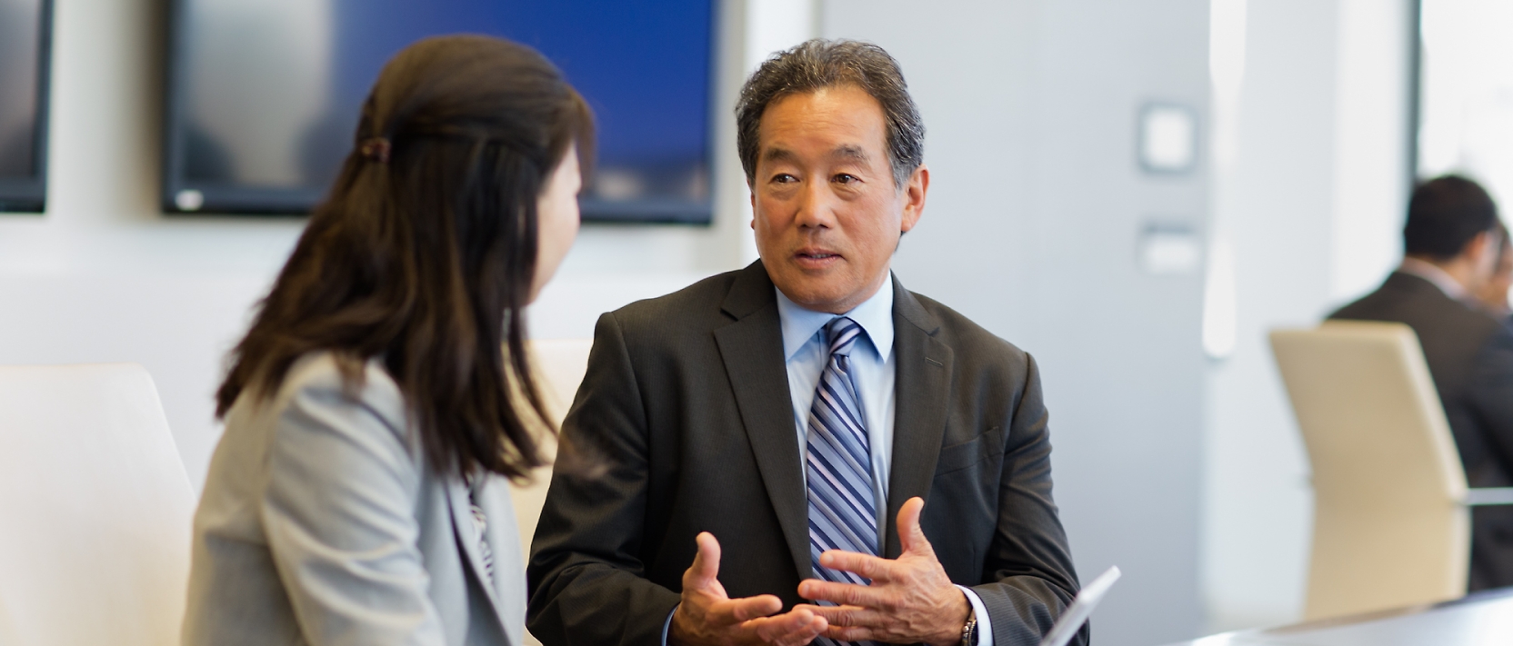 A man and woman talking in a conference room.