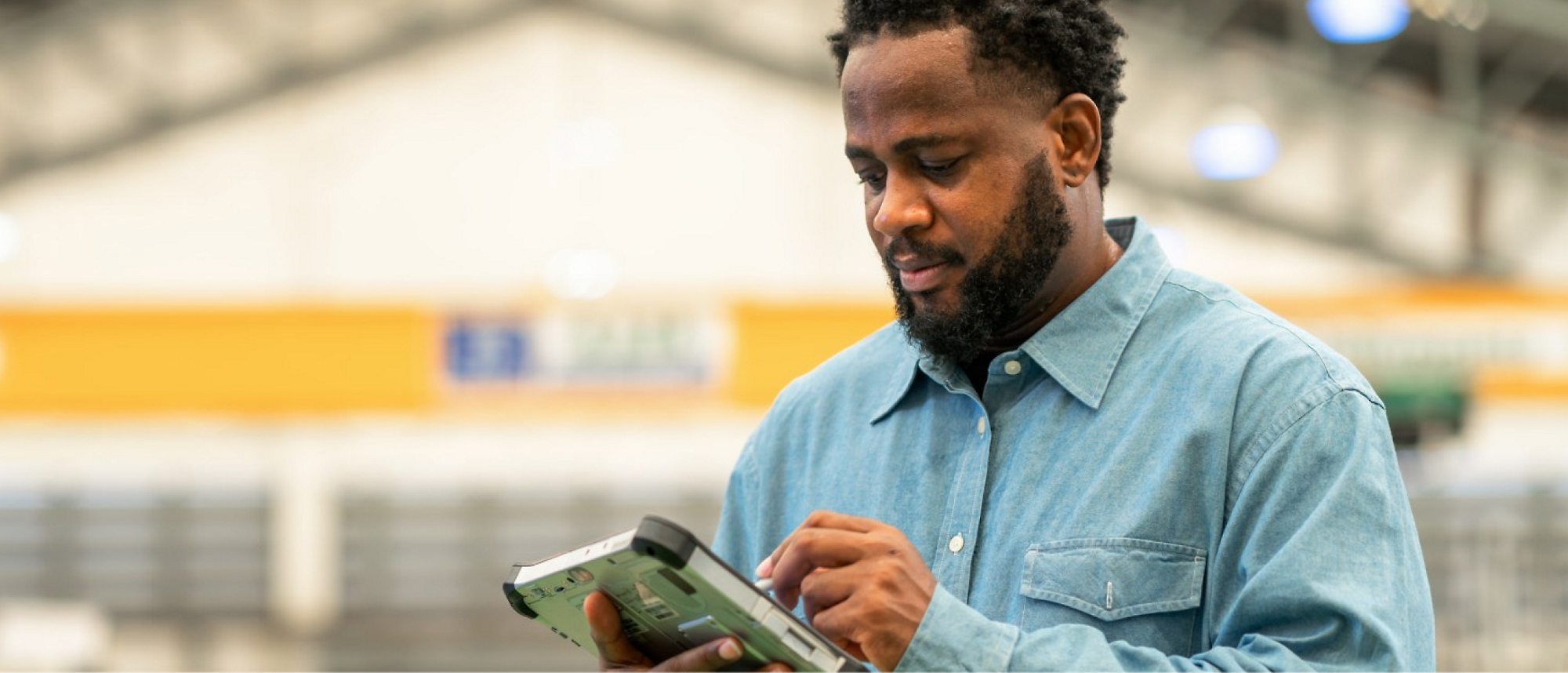 Een man die een tablet in een magazijn gebruikt.