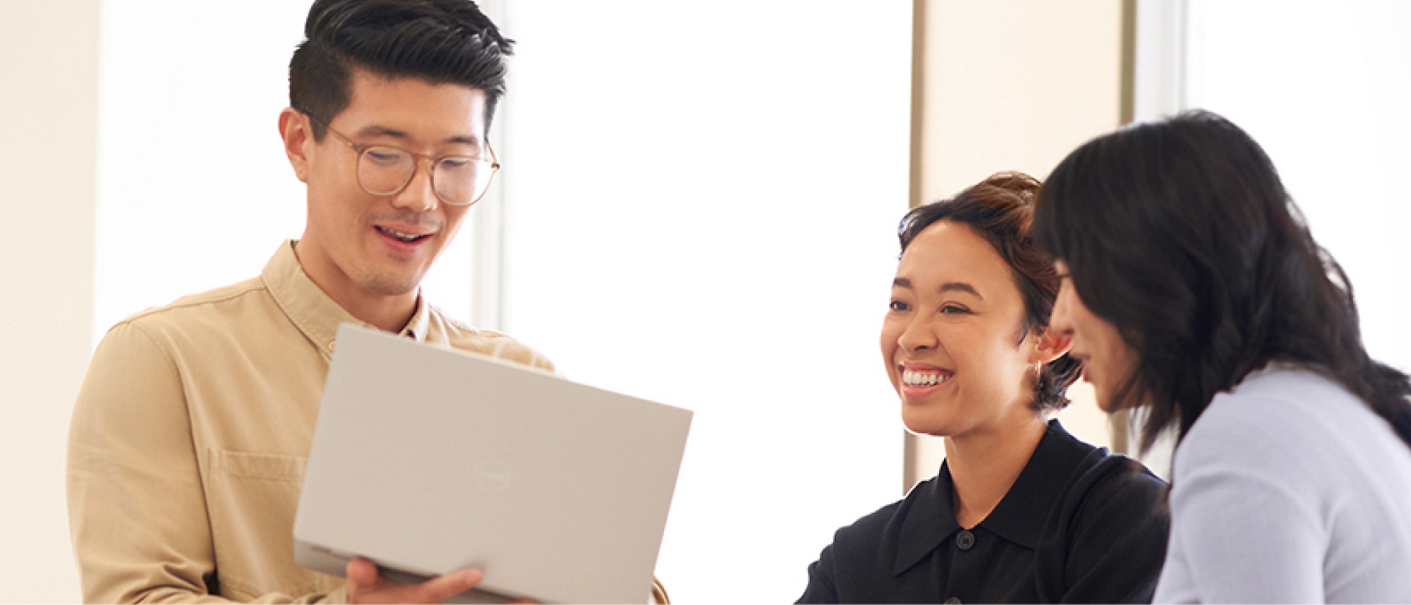 A group of people looking at a laptop.