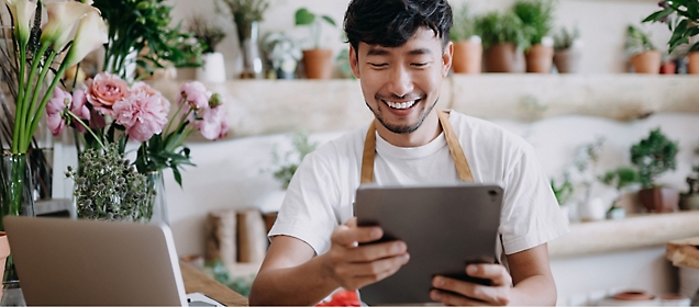 A person is using a tablet and smiling. 