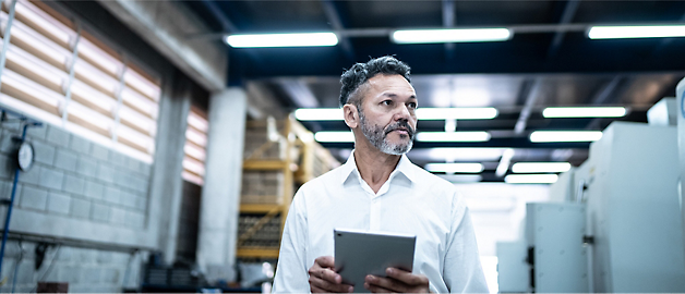 A person is wearing a white shirt and holding a tablet.