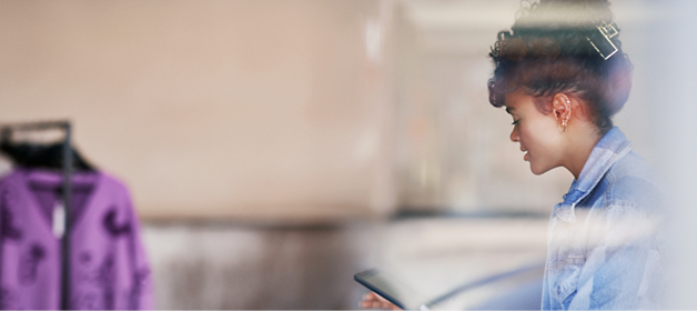 A girl wearing a blue shirt and using a tablet.