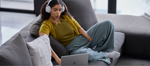 Une fille portant un casque et travaillant sur un ordinateur portable.