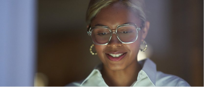 A woman wearing glasses is smiling at the camera.