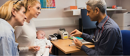 En lege tar seg av en babypasient som er sammen med sin mor