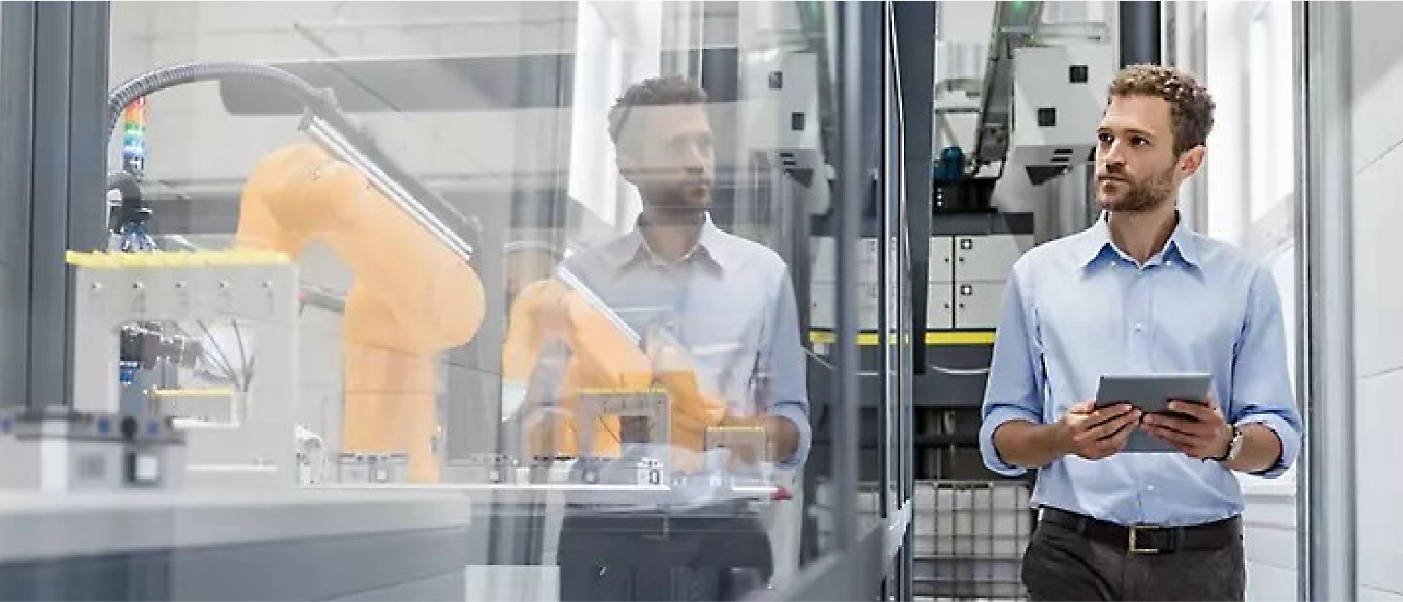 A man looking at a tablet in a factory.