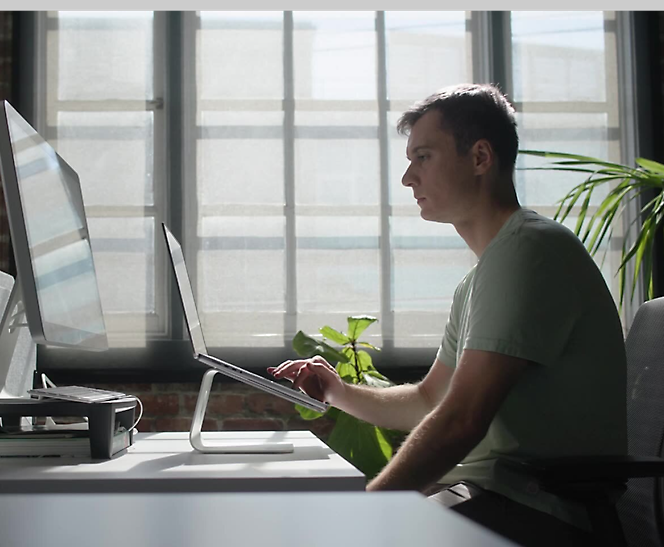 A person sitting in front of a computer screen.