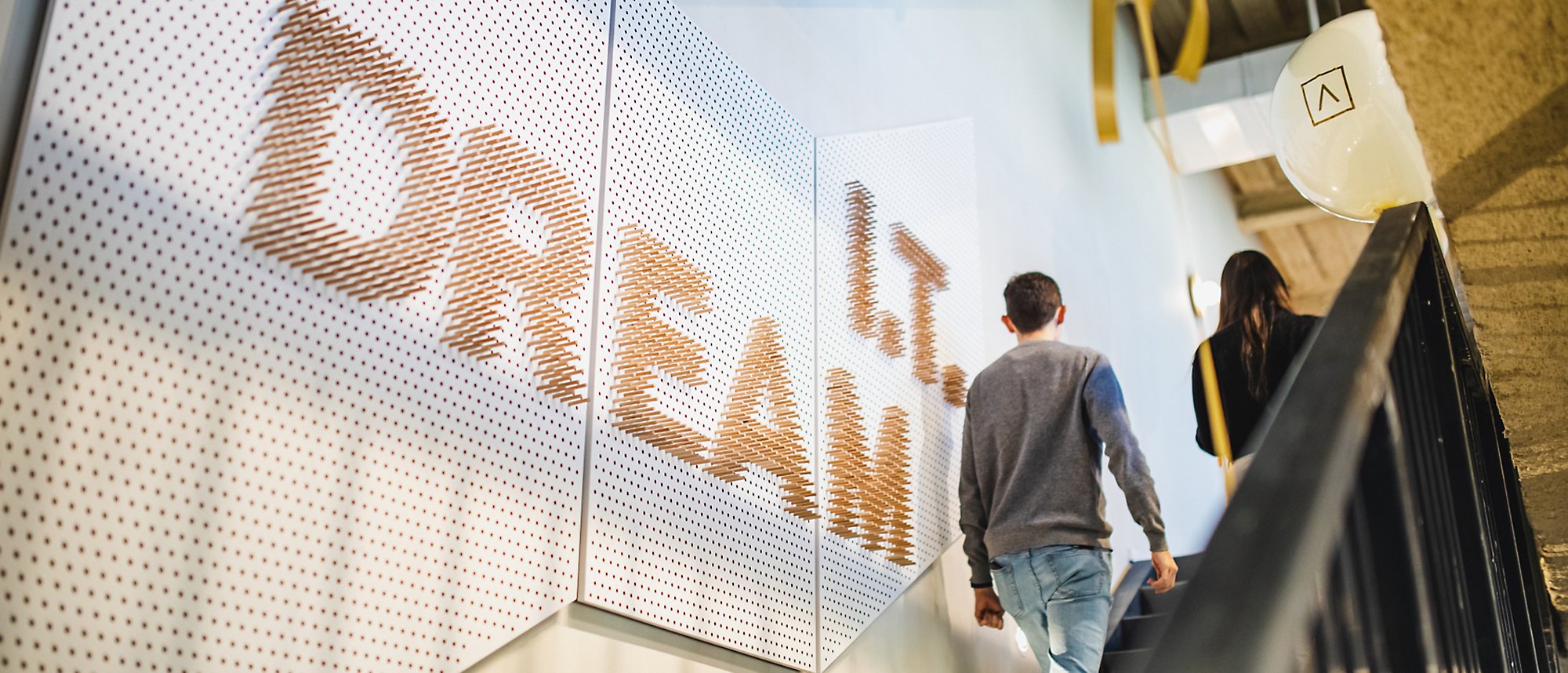 Two people walking up the stairs with a banner of IT dream on the wall