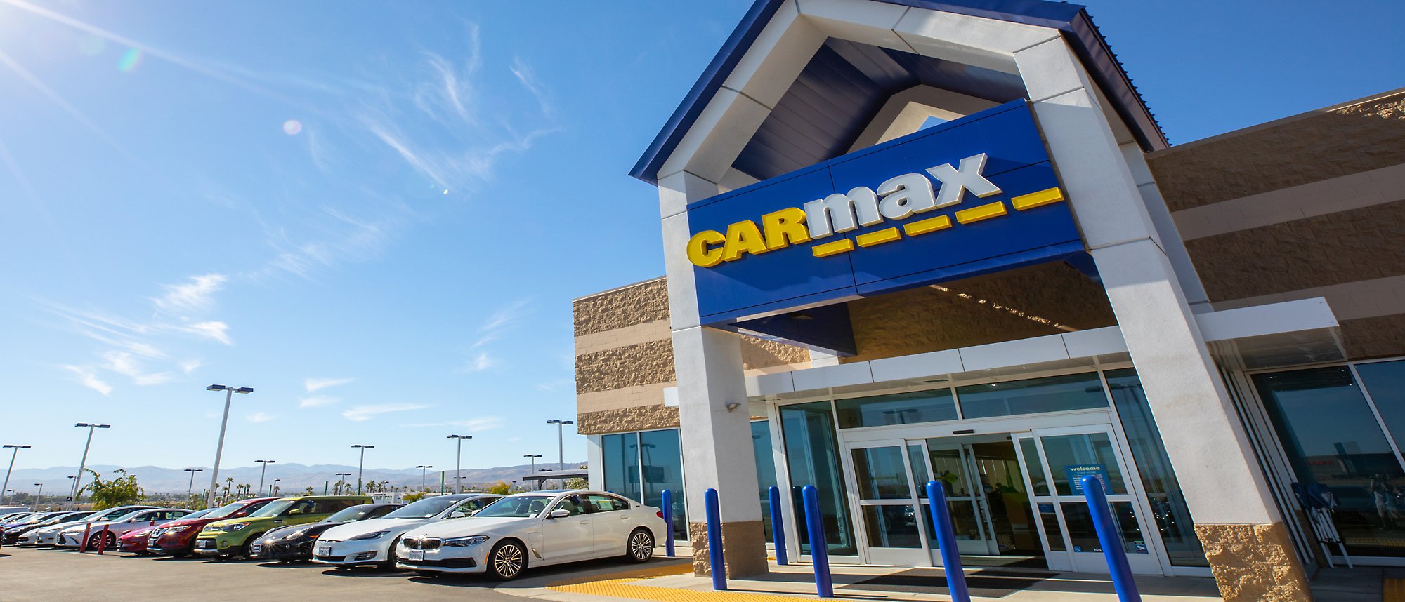 Een afbeelding van een CarMax-gebouw met veel buiten geparkeerde auto's