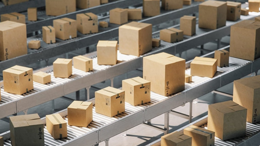 Cardboard boxes on conveyor belts in a distribution warehouse.