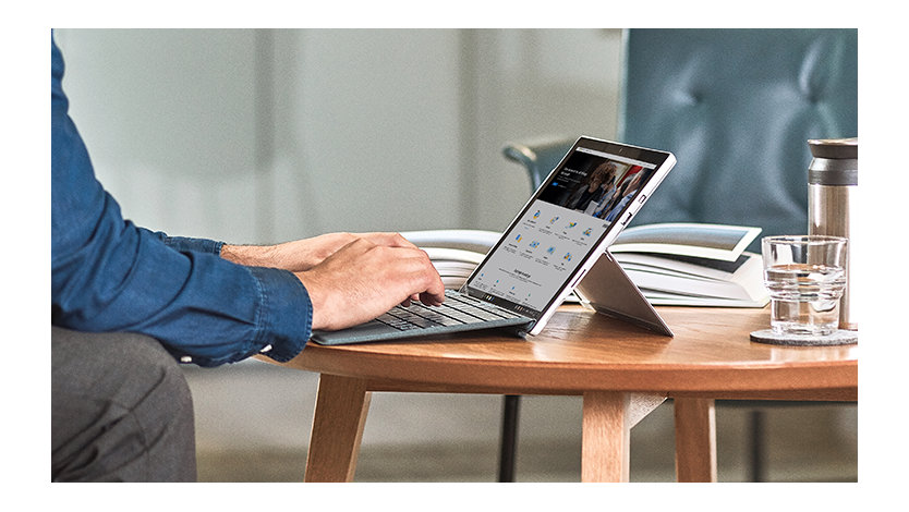 A person signing in on their Surface tablet on a coffee table.