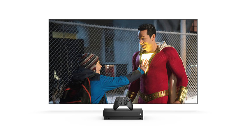 TV screen showing a boy touching a man chest that is lit up in a superhero costume.