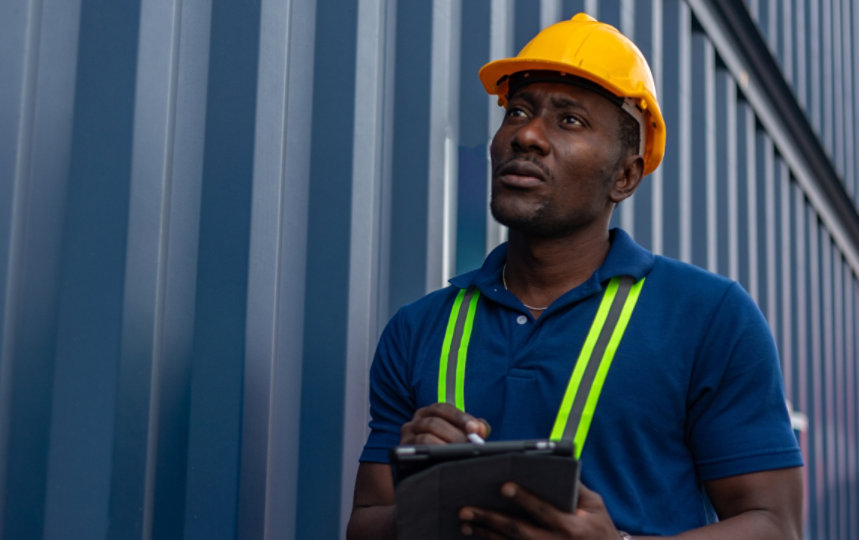 Foreman on a tablet control loading Containers box from Cargo freight ship.