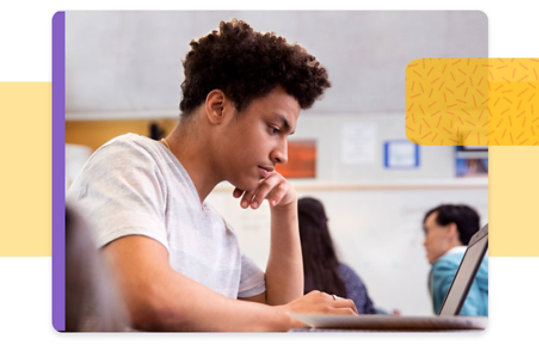 Young adult in classroom working on a laptop