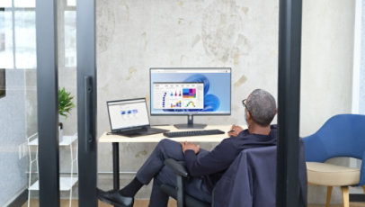 Man sitting in an office viewing Power BI UI within Windows 365, shown on Windows 11.